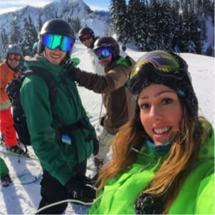 Rover teammates with ski gear on a snowy mountain smiling.