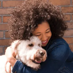 Vrouw die een vrolijke hond knuffelt
