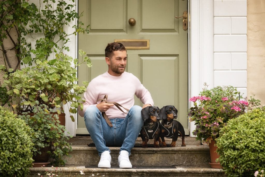 Adem Fehmi, a canine behaviourist, on his front porch with two dogs