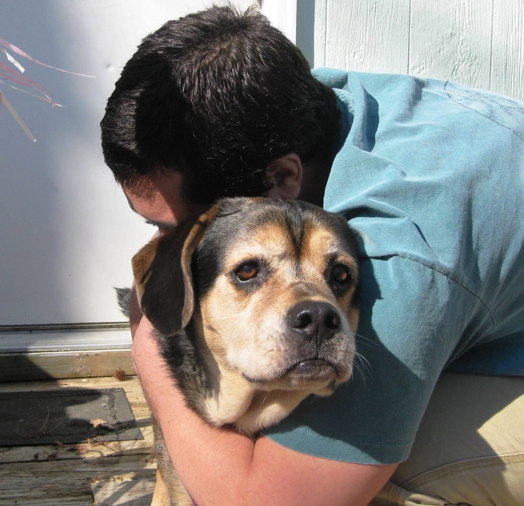 Man hugs dog - When is it okay to euthanize a pet