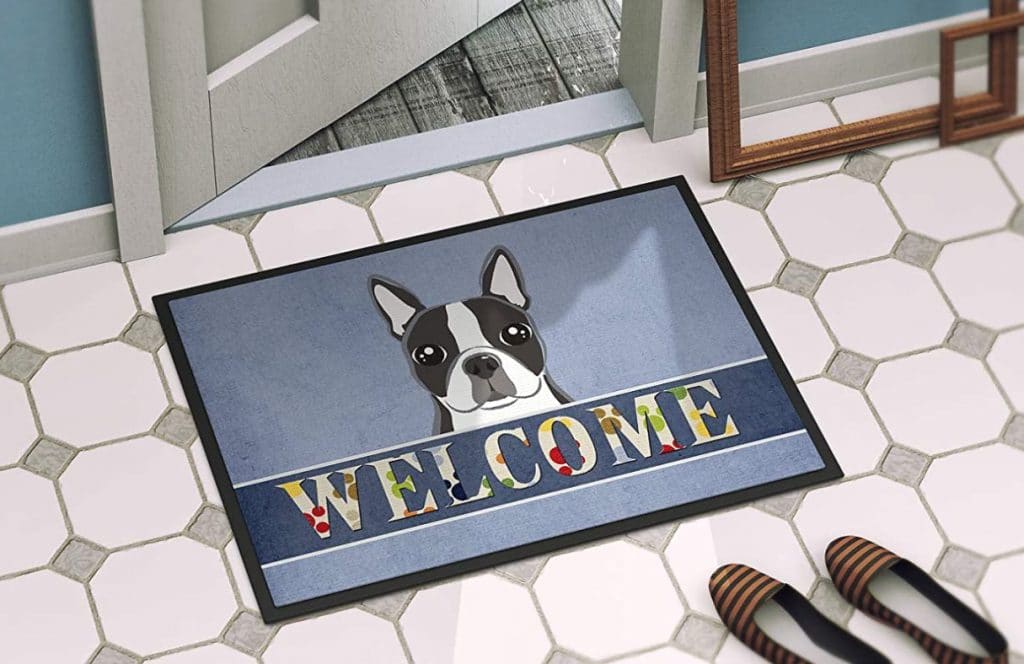 doormat with "Welcome" and a Boston Terrier peeking out on blue background