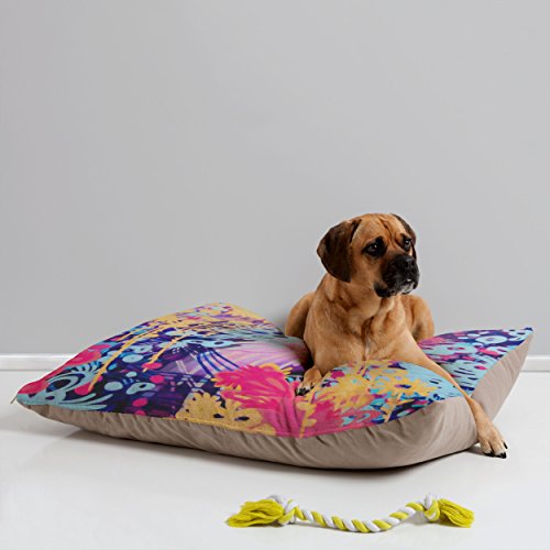 dog lying on pillow-style bed with colorful pattern on top