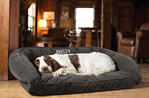 dog sleeping on dark gray quilted and personalized bolster bed