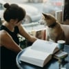 Woman sitting with dog reading in cafe