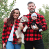 A family and dog wearing matching sweaters
