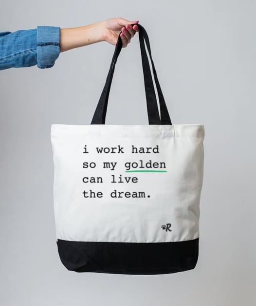 A tote bag reading "I work hard so my golden can live the dream," on the list of gifts for golden retriever lovers.