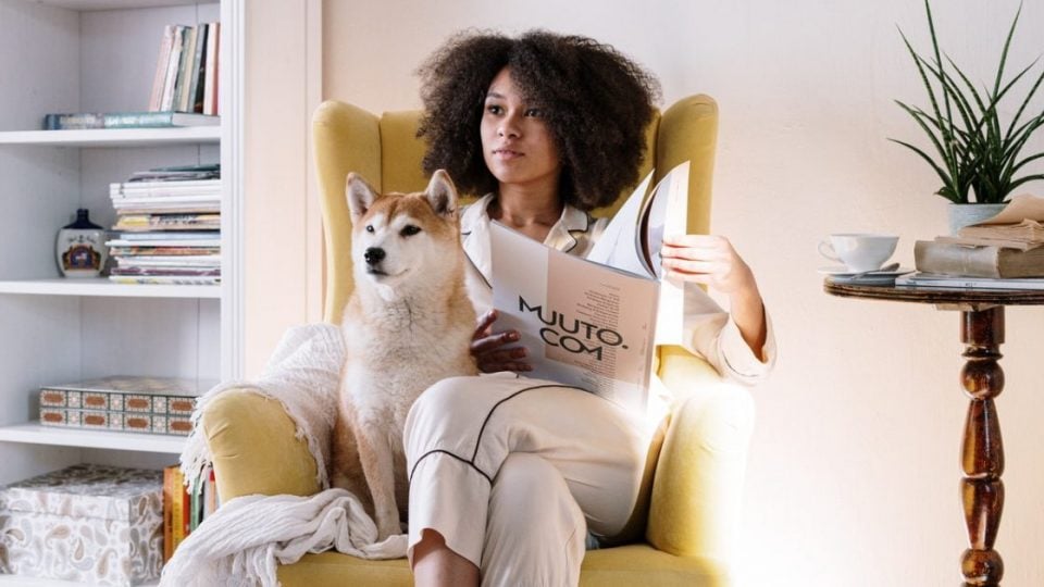 woman sitting in chair in PJs with dog