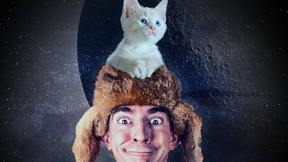 guy wearing fur cap and cat on top of hat