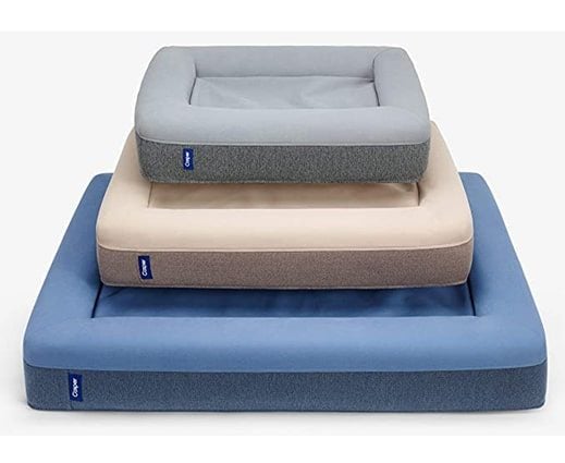 three Casper dog beds stacked on top of each other in gray, brown, and blue