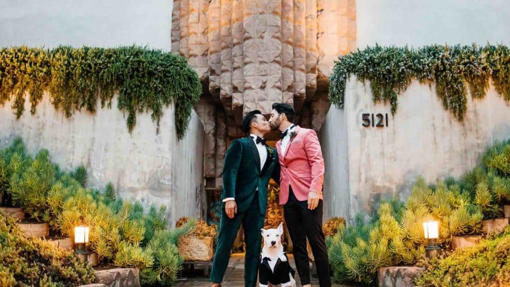 Two grooms with their dog, dressed up for their wedding