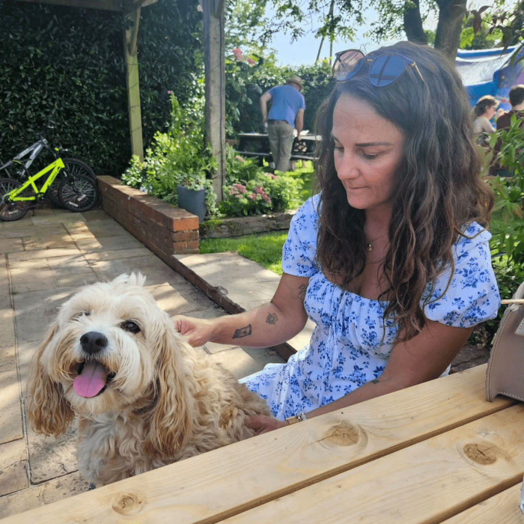 Dog and owner in the pub garden of the Hare & Hound