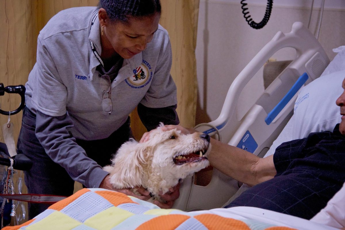 Dr. Terry Morris and shelter dog Axel visit a patient