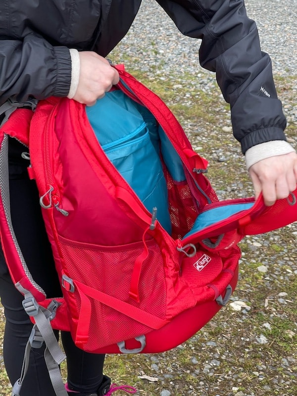 Person holds the Kurgo G-Train Dog Hiking Backpack open to show inner pockets