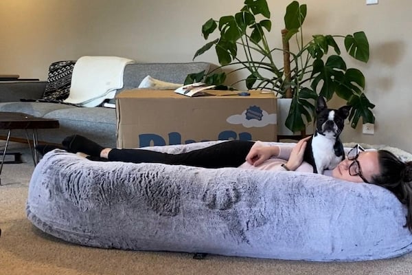 Woman naps with dog in Plufl human dog bed