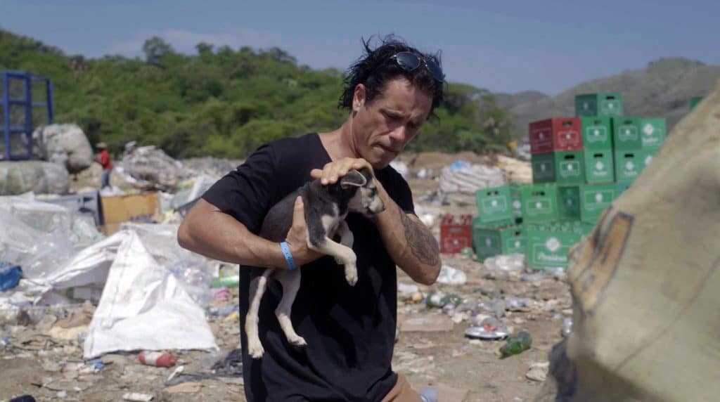 Doug Thron with a small puppy he found in a pile of rubble