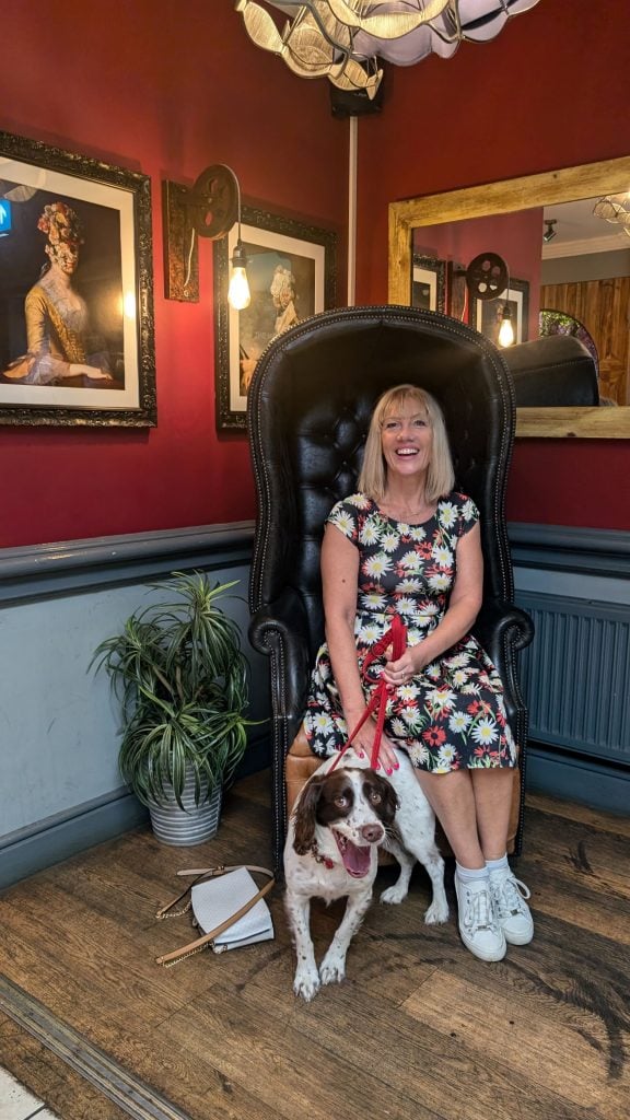 A woman and her dog smiling in the corner of a pub, The Malt House, Kingsbury