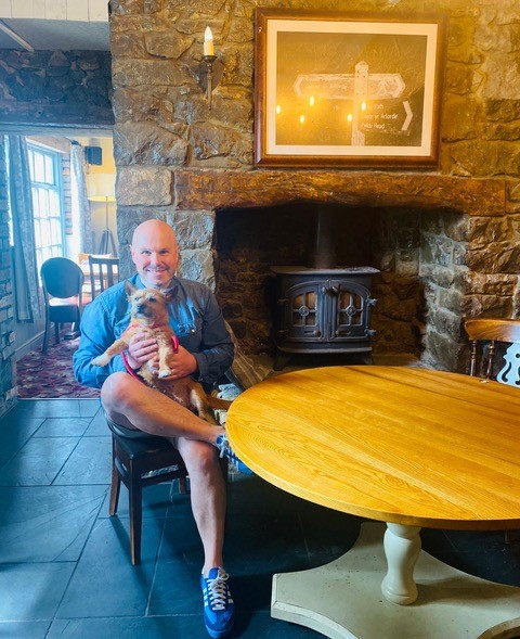 Man and his dog sitting at a table in The Beaufort Arms
