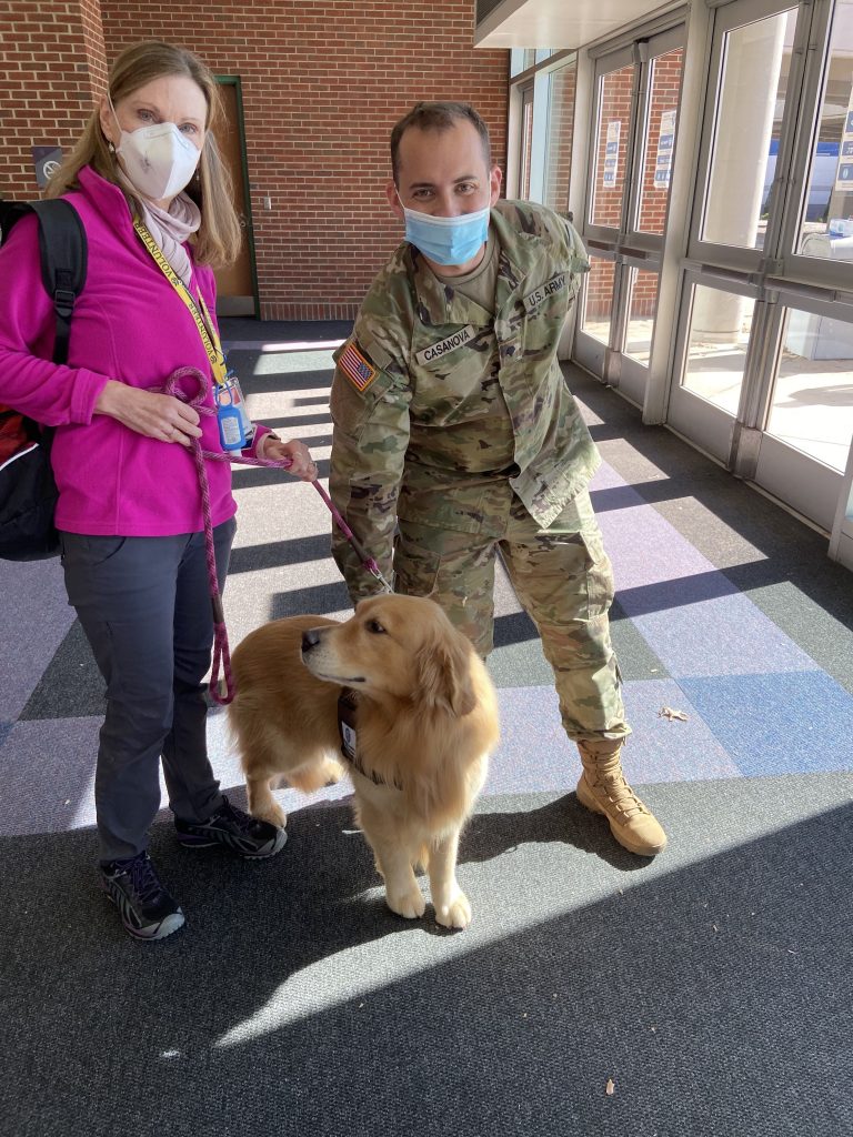 Theo greets a soldier helping direct attendees at a Covid-19 vaccination clinic