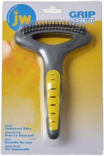 A grey and yellow rake-style dog brush in plastic and cardboard packaging. 