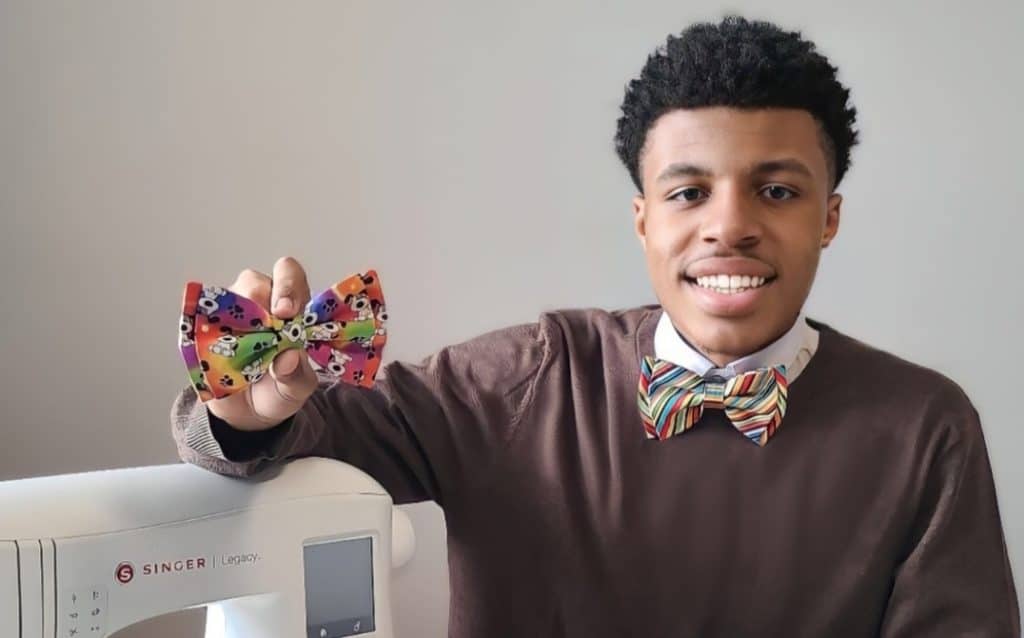 Sir Darius Brown, founder of Beaux and Paws, holding a handmade bow tie