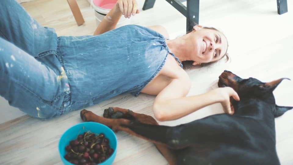 Person lying on deck eating cherries with dog
