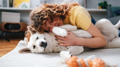 Person lying on floor with dog