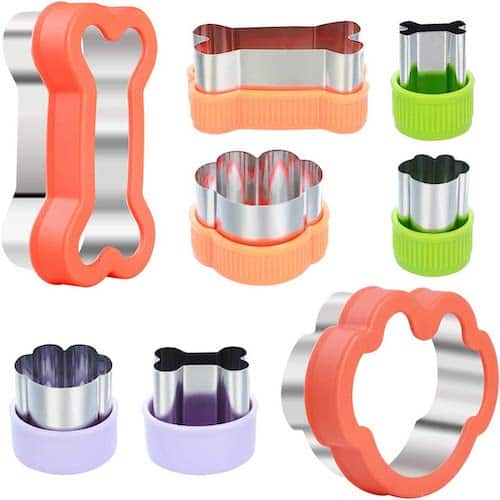 a variety of paw and bone-shaped cookie cutters with purple, green, and orange grips; essential dog baking gear