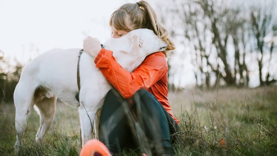 Woman giving dog hug while out running