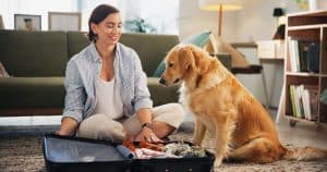 Packing suitcase while dog watches