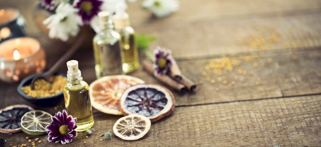 Essential oils on a wood table against a natural background.