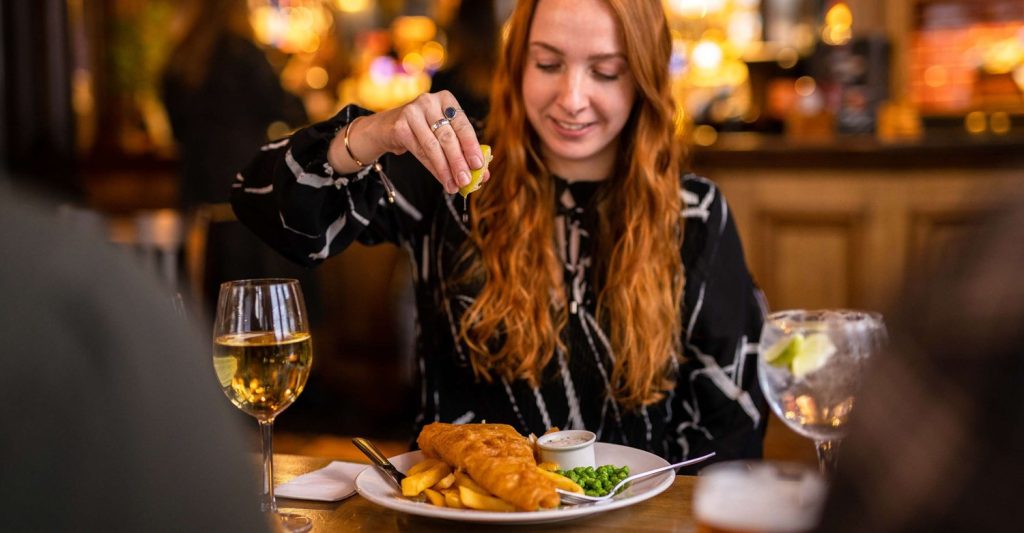 woman eating fish and chips