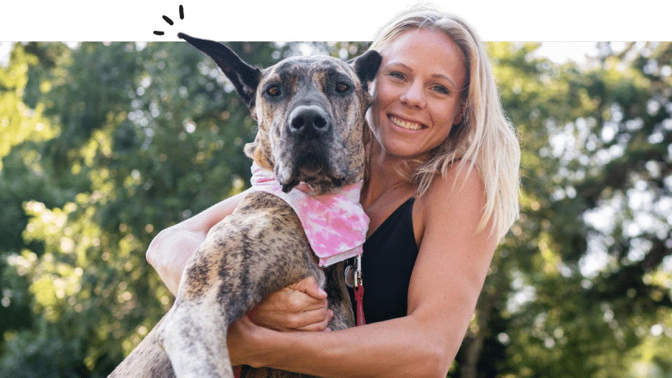 Woman hugs big dog in park