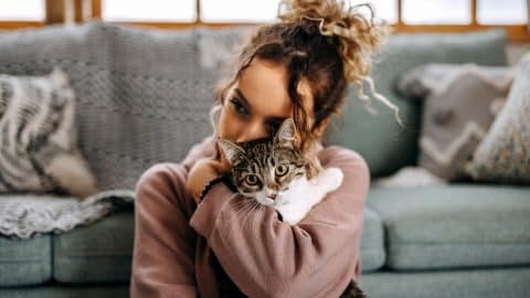 Young woman bonding with her cat in apartment