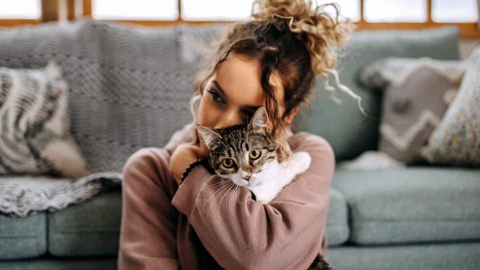 Young woman bonding with her cat in apartment