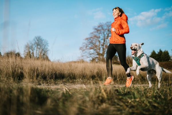 Woman jogs with dog in cold clear day