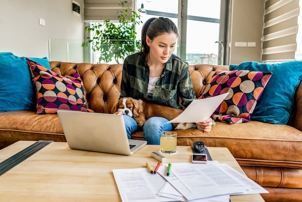 woman working from home in the company of her puppy 