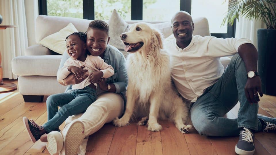 Young family relaxes in the living room with their Labrador retriever