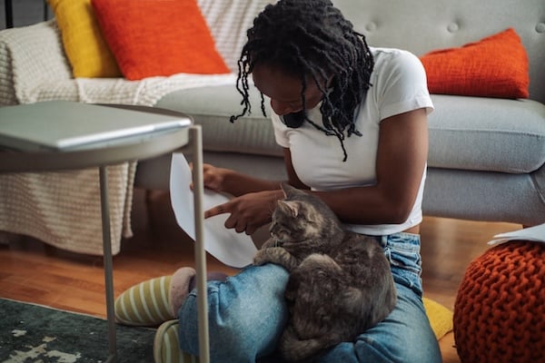 Woman reads instructions to cat