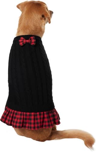 Dog wearing a black and plaid sweater dress.