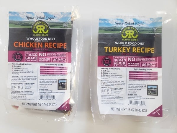 Two packages of Raised Right cat food in turkey and chicken recipes