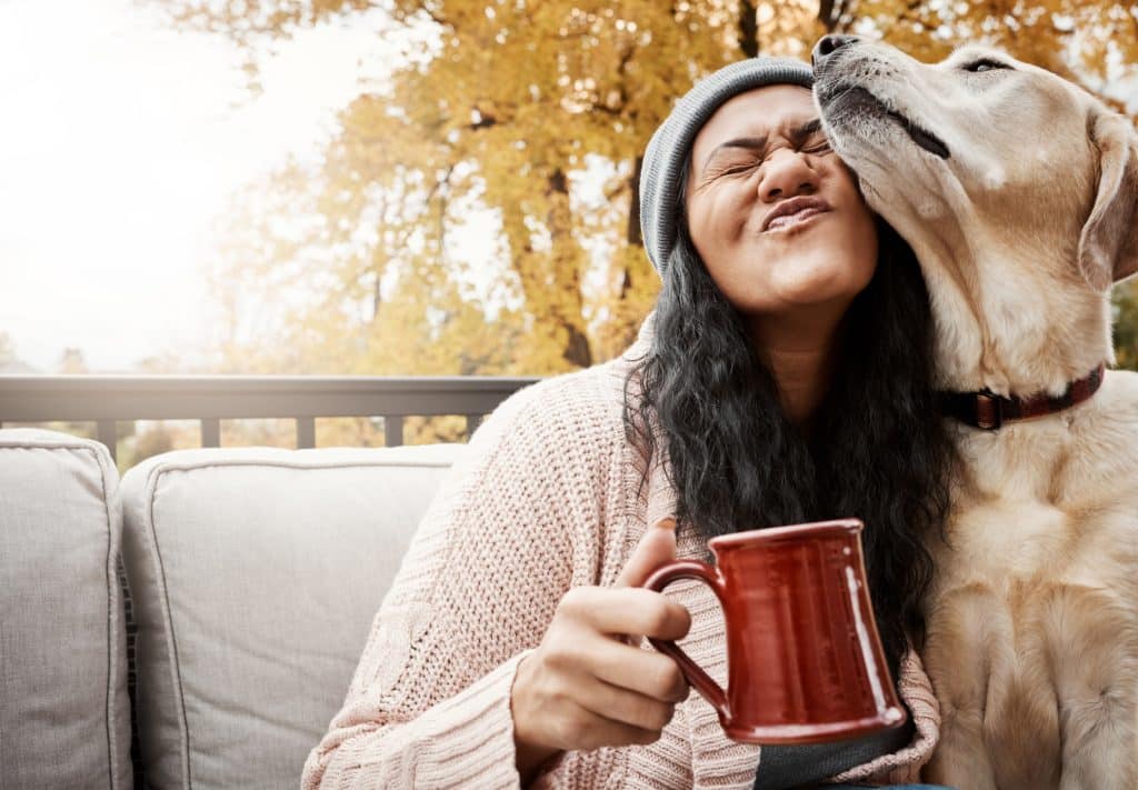 Shot of a young woman relaxing with her dog outside